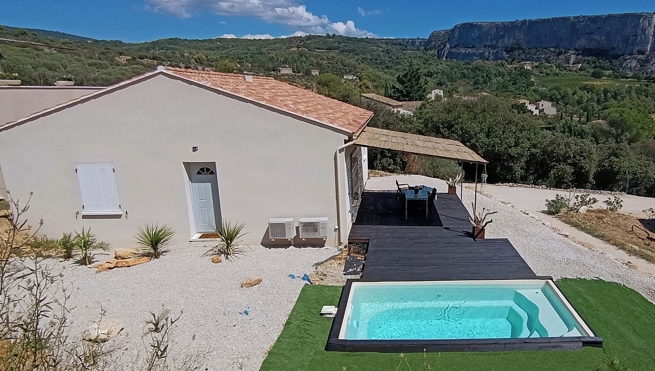 Une maison avec une piscine, un patio couvert et une vue sur une montagne.