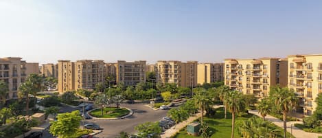 A residential complex with multiple apartment buildings, a central roundabout, and surrounding greenery.