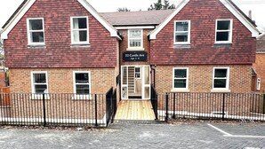 A two-story building with a brick facade, a sign reading "22 Castle Ave Apt 1-6", and a gated entrance.