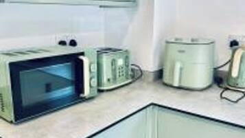 Eine Küche mit Mikrowelle, Toaster und Kaffeemaschine auf der Arbeitsplatte.