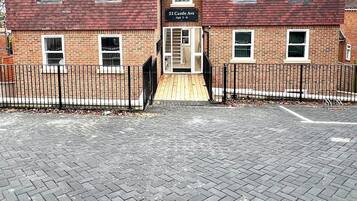 A two-story building with a brick facade, a sign reading "22 Castle Ave Apt 1-6", and a gated entrance.