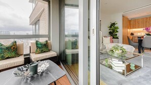 A modern apartment with a balcony, a dining area, and a kitchen. - The King’s Cross Residence — AC Studio by Station (London)