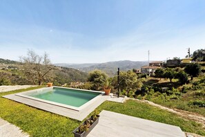 Une piscine avec vue sur un paysage vallonné.