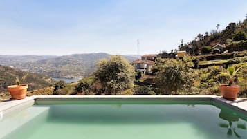 Una piscina con vistas a un paisaje montañoso y casas.