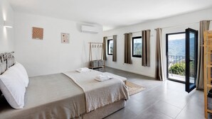 Ein Schlafzimmer mit Bett, Schrank, Fenster und Balkon.