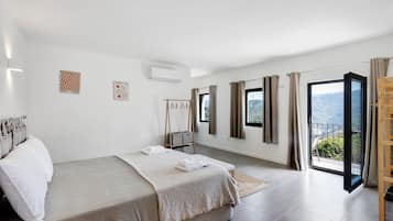 Un dormitorio con cama, armario, ventana y balcón.