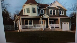 A two-story house with a front porch and a garage. - Walking distance Golf Course 4-bedroom house with Living  Dining and Family Room (Farmingdale)