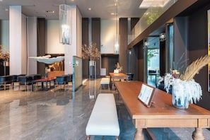 A modern lobby with a long reception desk, seating area, and large windows. - Haoze Ruizhi Hotel (Penglai Pavilion Baxianguohai) (Yantai)