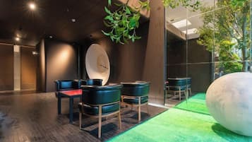 A modern interior with a reception desk, seating area, and a large spherical sculpture.