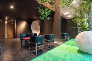 Un intérieur moderne comprenant un comptoir d’accueil, un espace détente et une grande sculpture sphérique.