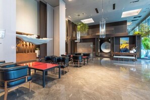 A modern lobby with seating areas, a reception desk, and a large window. - Haoze Ruizhi Hotel (Penglai Pavilion Baxianguohai) (Yantai)