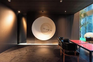 A modern interior with a circular light feature, a dining table, and chairs. - Haoze Ruizhi Hotel (Penglai Pavilion Baxianguohai) (Yantai)