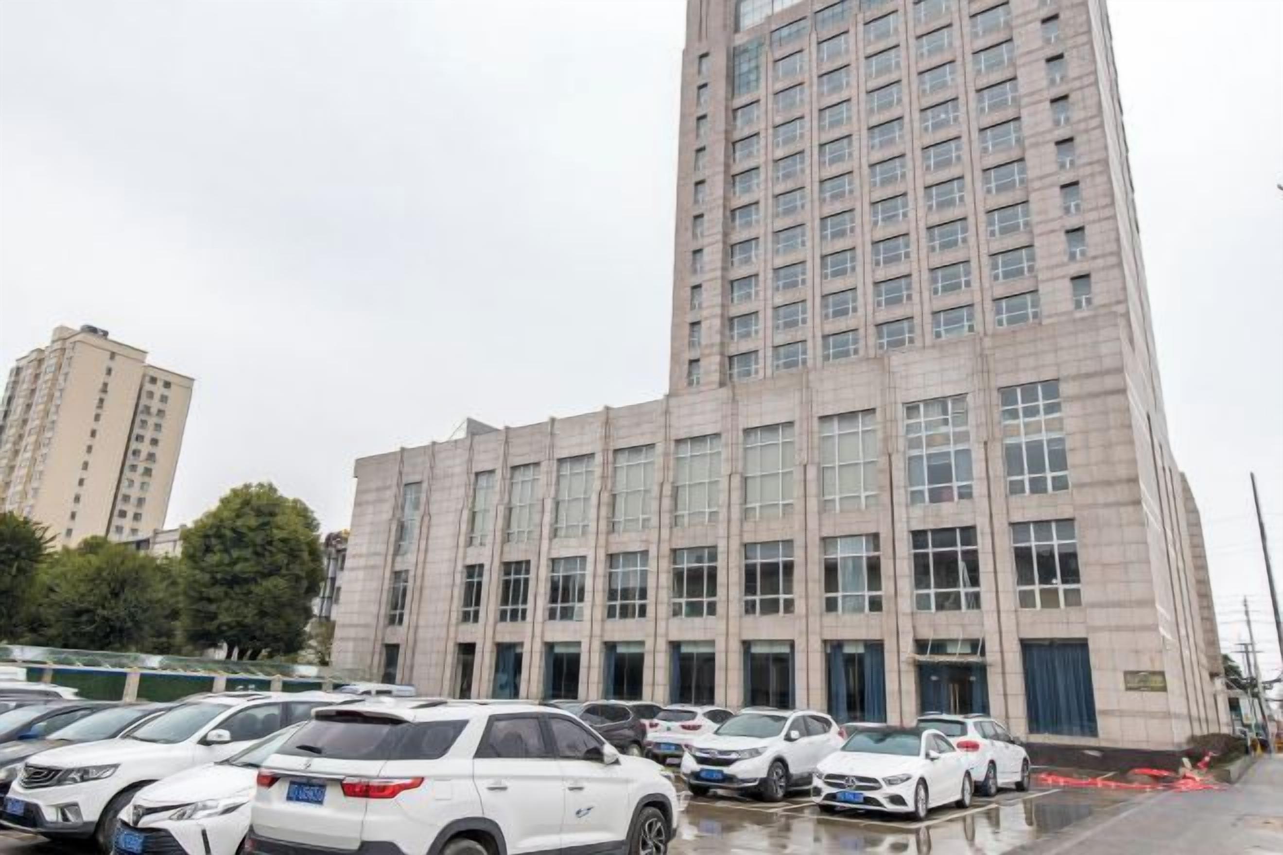 A multi-story building with a parking lot in front.
