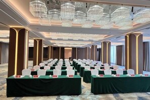 A conference room with rows of tables, chairs, and a chandelier. - Phoenix Court Hotel (Jingzhou Ancient City Changjiang University) (Jingzhou)