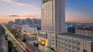 A high-rise hotel with a modern design, featuring a prominent entrance and multiple floors. - Phoenix Court Hotel (Jingzhou Ancient City Changjiang University) (Jingzhou)