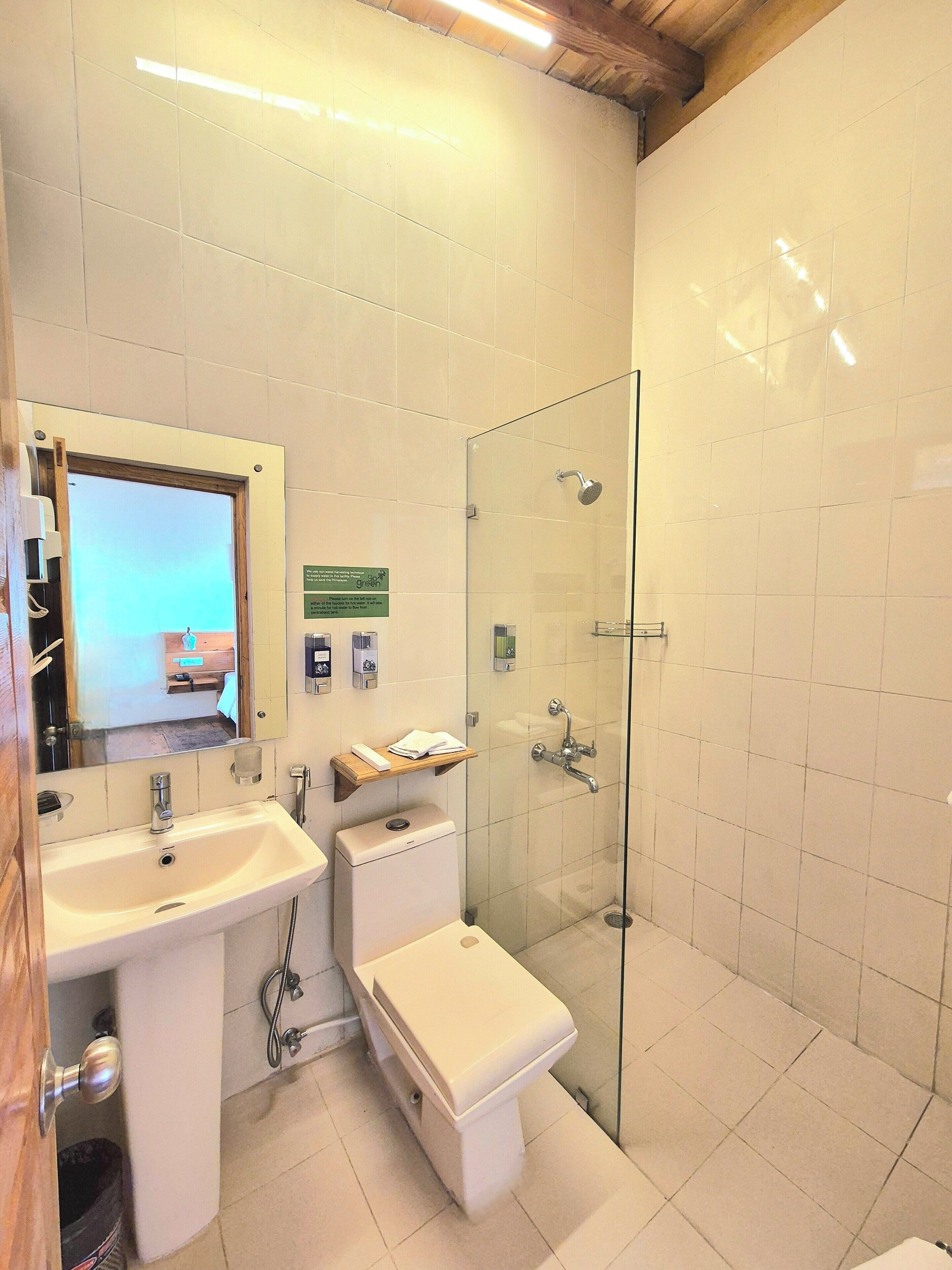 A bathroom with a sink, toilet, and glass-enclosed shower.