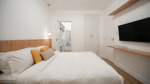 A bedroom with a bed, a TV, a wardrobe, and a walk-in closet. - Leblon | 5min to Beach & Perfect Location (Rio de Janeiro)