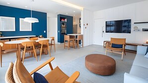 A modern living room with a sofa, ottoman, and dining area. - Leblon | 3 dorms | 6 minutes from the beach (Rio de Janeiro)
