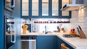 A modern kitchen with built-in appliances, a central island, and a window overlooking the city. - Leblon | 3 dorms | 6 minutes from the beach (Rio de Janeiro)