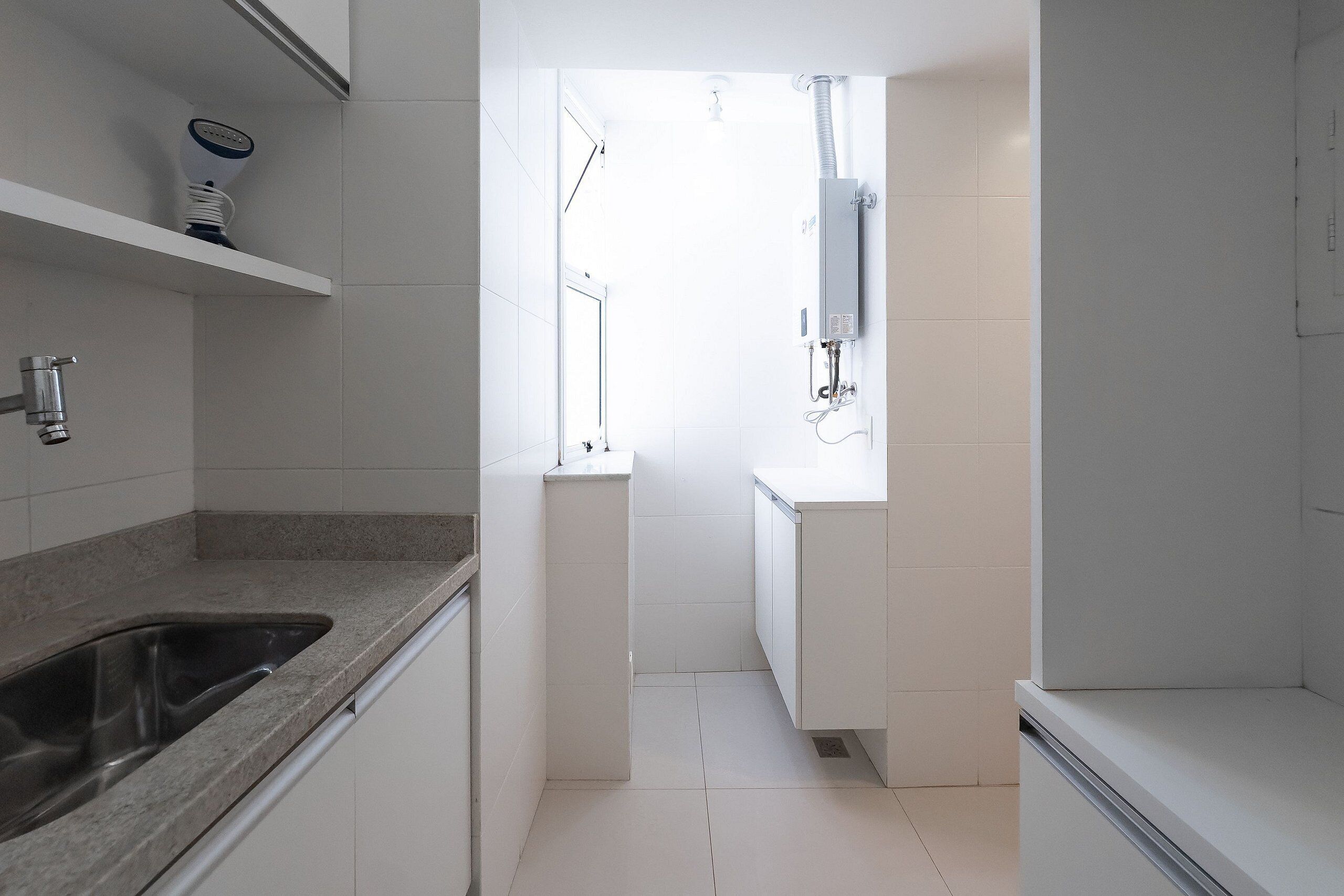 A modern kitchen with a granite countertop, a stainless steel sink, and a built-in oven.