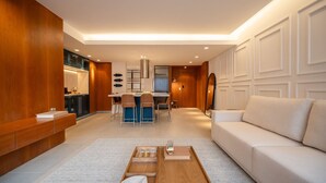 Una sala moderna con sofá, mesa de centro y un comedor con sillas y una mesa.