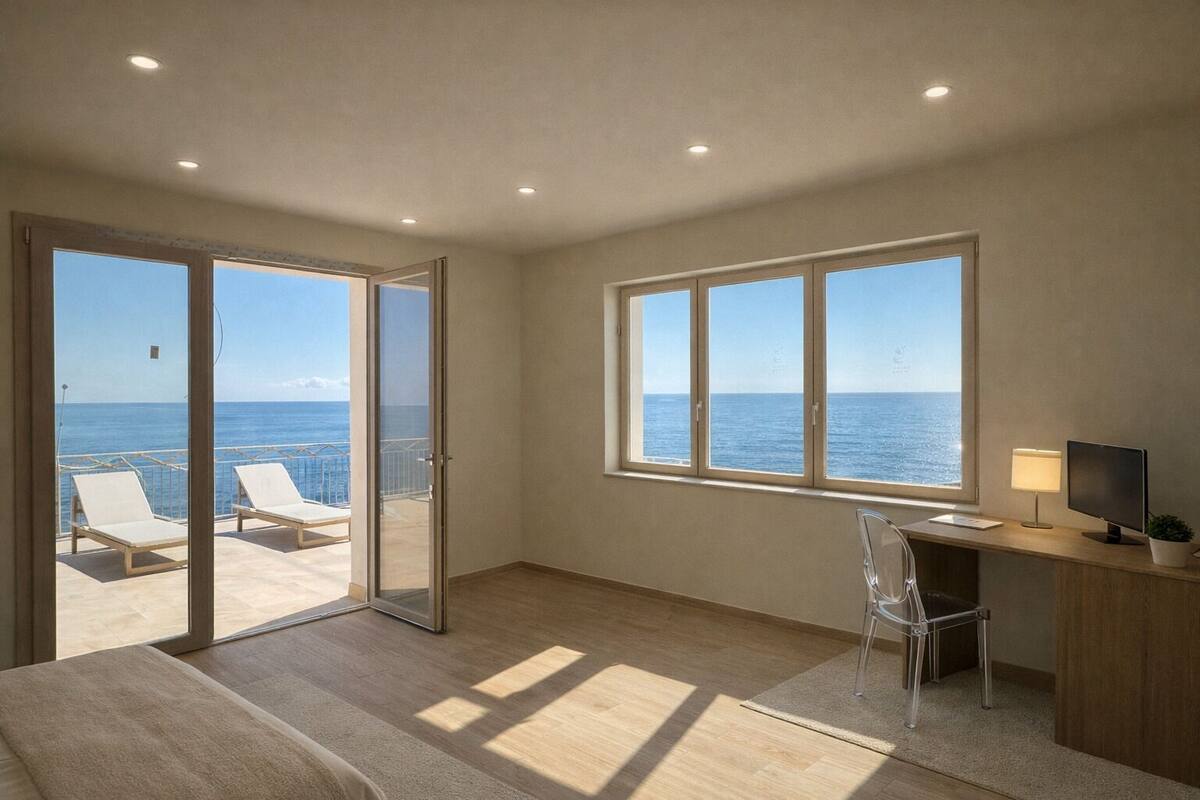Une chambre avec un balcon, un bureau avec un ordinateur et une chaise.