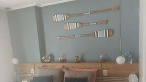 Une chambre à coucher avec un lit, des tables de chevet et des palettes en bois fixées au mur.