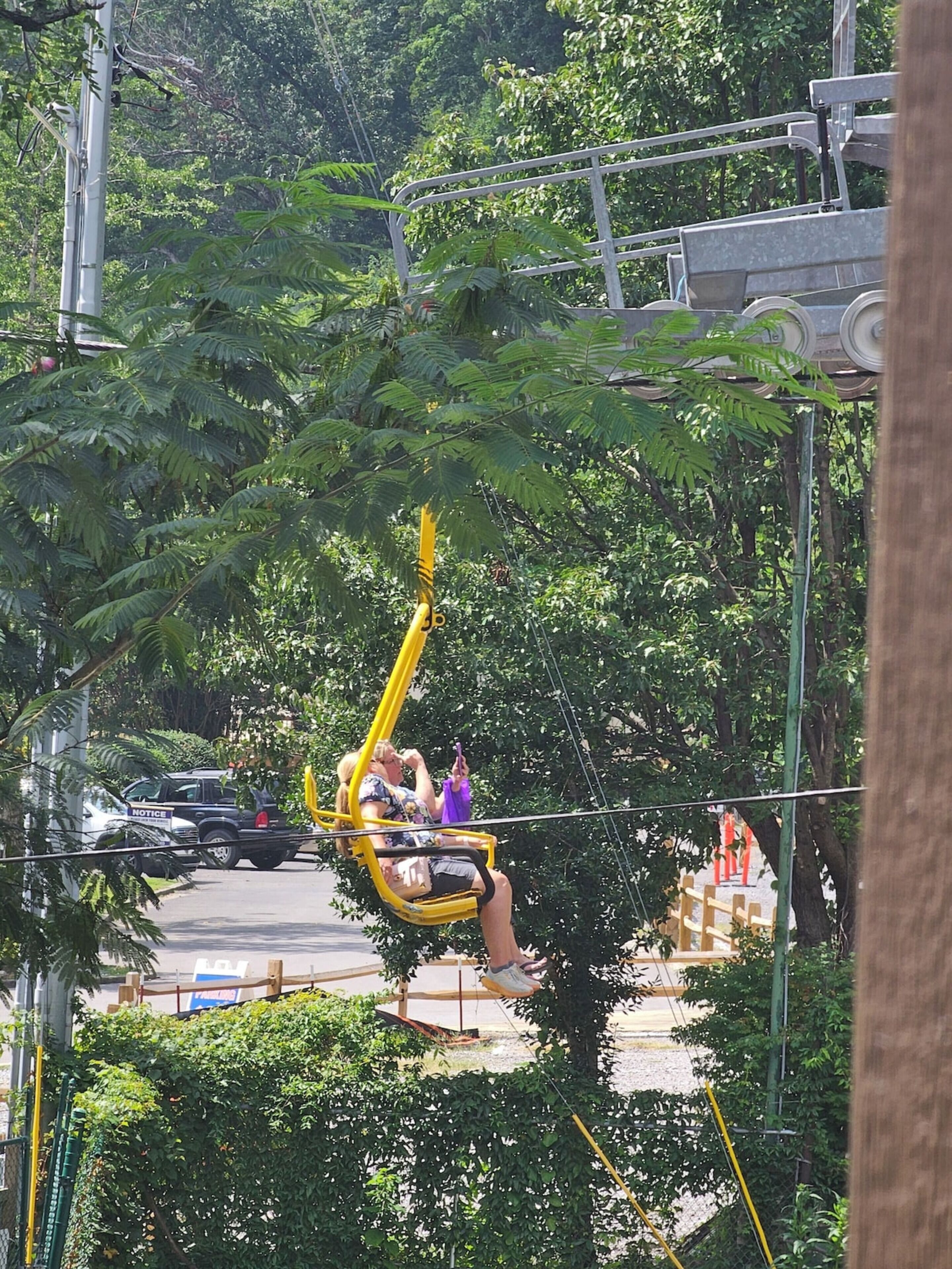 A swing ride with a yellow frame and a person on it.