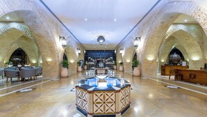 A lobby with a central fountain, arched ceilings, and a reception desk. - Grand Waterworld Makadi couples and families only (Makadi Bay)