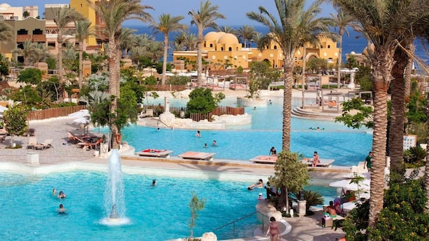 A resort with multiple swimming pools, palm trees, and Mediterranean-style architecture. - Grand Waterworld Makadi couples and families only (Makadi Bay)