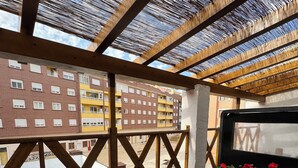 A balcony with a view of a building, a pool, and outdoor furniture. - Casa Ribera Maya (Aranda de Duero)