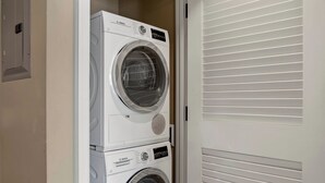 A Bosch washing machine stacked on top of another Bosch washing machine in a laundry room with a white door and blinds. - Honua Kai | Ocean View 5 BR, Sleeps 16 | Car Incl. w/ 6+ Nights | HKH ML-1616 by KBM (Lahaina)