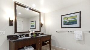 A bathroom with two sinks, a large mirror, a framed picture on the wall, and a towel rack. - Honua Kai | Ocean View 5 BR, Sleeps 14 | Car Incl. w/ 6+ Nights | HKH ML-1634 by KBM (Lahaina)