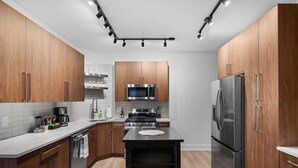 A modern kitchen with wooden cabinets, stainless steel appliances, and a central island. - Pristine Double King 3BR suite | A+ Location| ADA| (Pittsburgh)