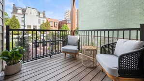 A wooden deck with two grey upholstered chairs and a small round table. - Immaculate Double King Suite | 4 beds | 2 Decks (Pittsburgh)