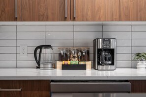 Una cocina con cafetera, hervidor y especias.