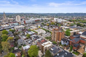 A cityscape with a prominent church spire, a mix of residential and commercial buildings, and a clear view of the surrounding hills.
