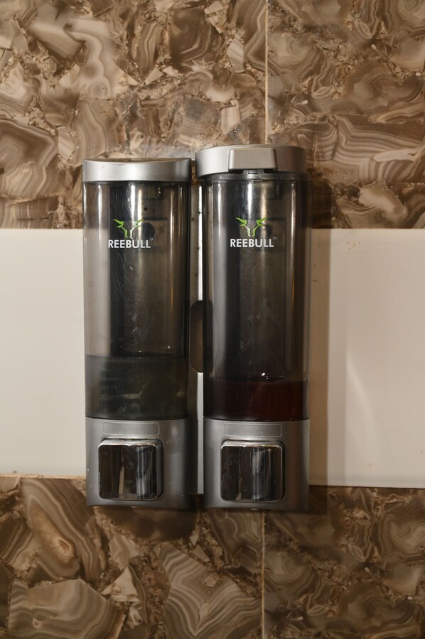 Dois dispensadores de bebidas Red Bull fixados numa parede com padrão semelhante ao mármore.