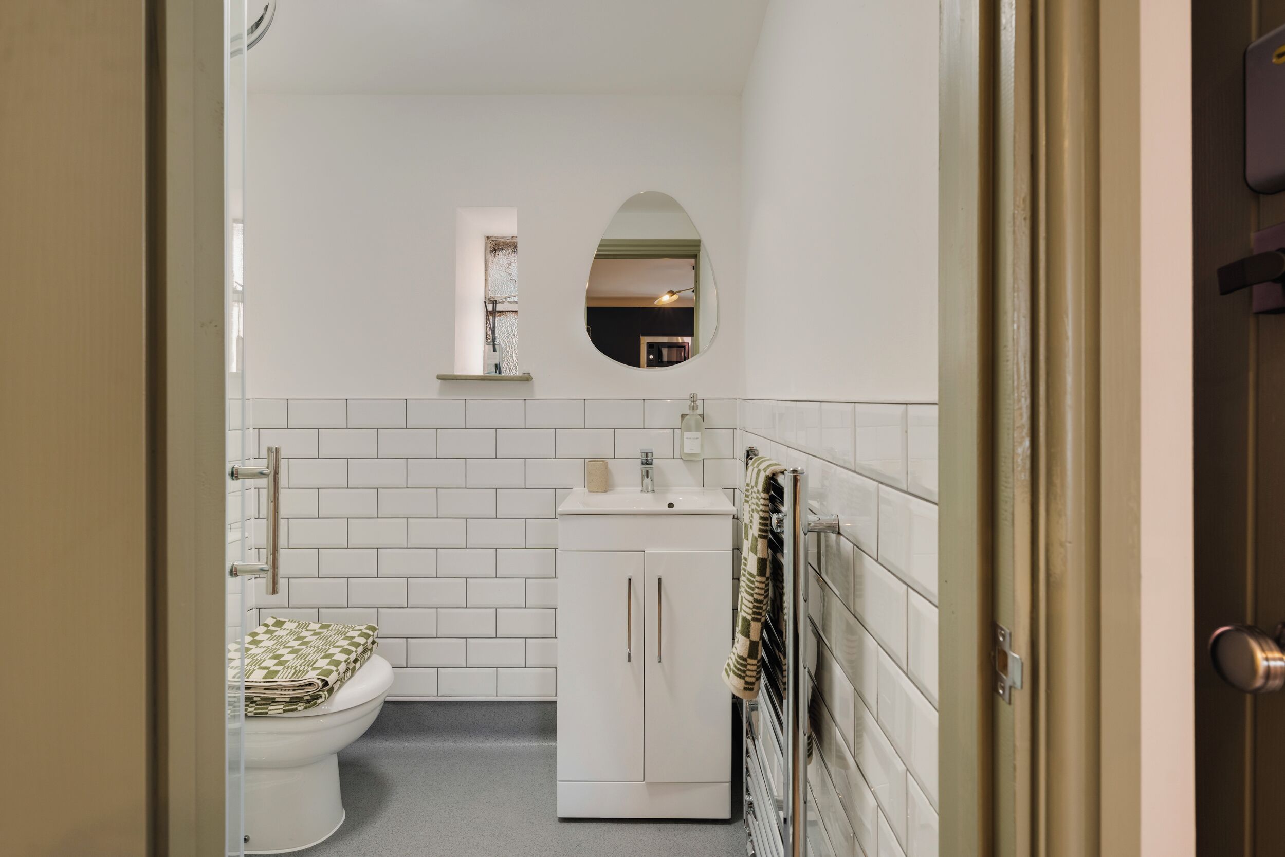 A bathroom with a toilet, sink, and mirror.