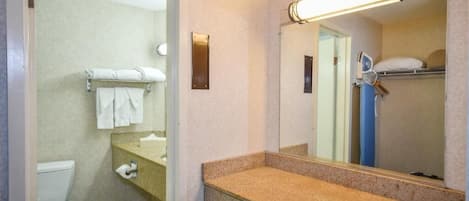 Une salle de bain avec des toilettes, un lavabo et un miroir.