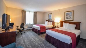 A hotel room with two beds, a desk with a computer, a chair, and a TV. - Charles River Inn (Boston)