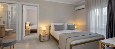 Ein modernes Hotelzimmer mit einem großen Bett, Nachttischen, einem Schreibtisch und einem durchgegangenen Tür sichtbaren Badezimmer.