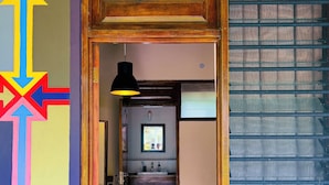 A hallway with a number '10' sign, a colorful directional sign, a sink with toiletries, and a window with blinds. - Ko-Sa Beach Resort (Ampenyi)