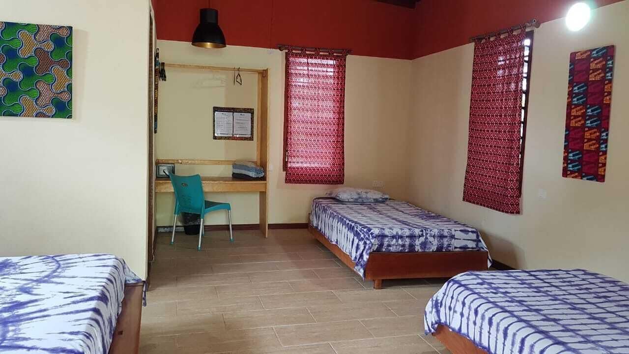 Una habitación tipo dormitorio con dos camas individuales, un escritorio y una silla.