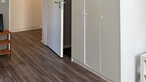 A room with a wardrobe, a door, and a wooden floor. - Three Bedroom Comfort Apartment Maintal (Maintal)