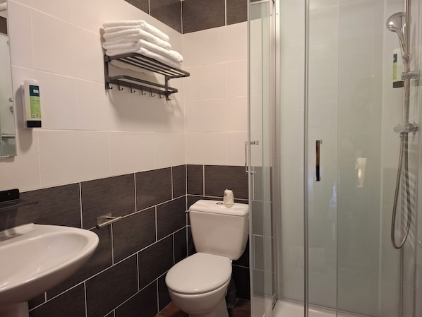 A modern bathroom with a toilet, sink, and glass-enclosed shower. - RELAIS LES 200 BORNES (Pouilly-sur-Loire)