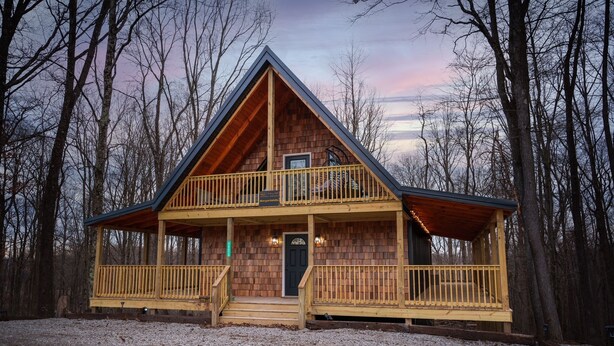 A log cabin with a two-story porch and a front door. - Margaritahills is the perfect getaway for  two couples, where rustic elegance meets modern comfort. (Creola)