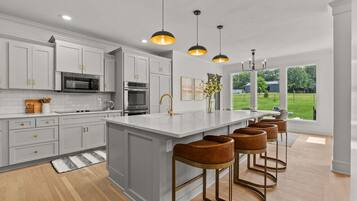 Dishwasher, coffee/tea maker, cookware/dishes/utensils, dining tables