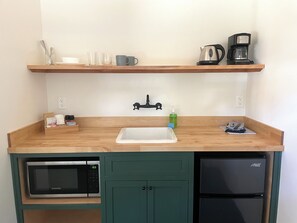 Fridge, coffee/tea maker, cookware/dishes/utensils, dining tables