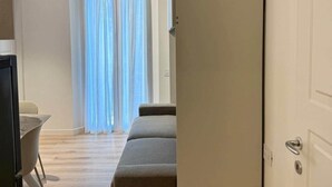 Une chambre avec un lit, un bureau et une fenêtre avec des rideaux.